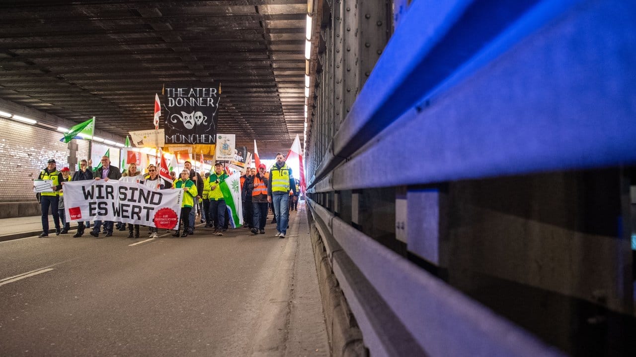 Warnstreik in Bayern: Demonstranten gehen mit Plakaten durch einen Tunnel.