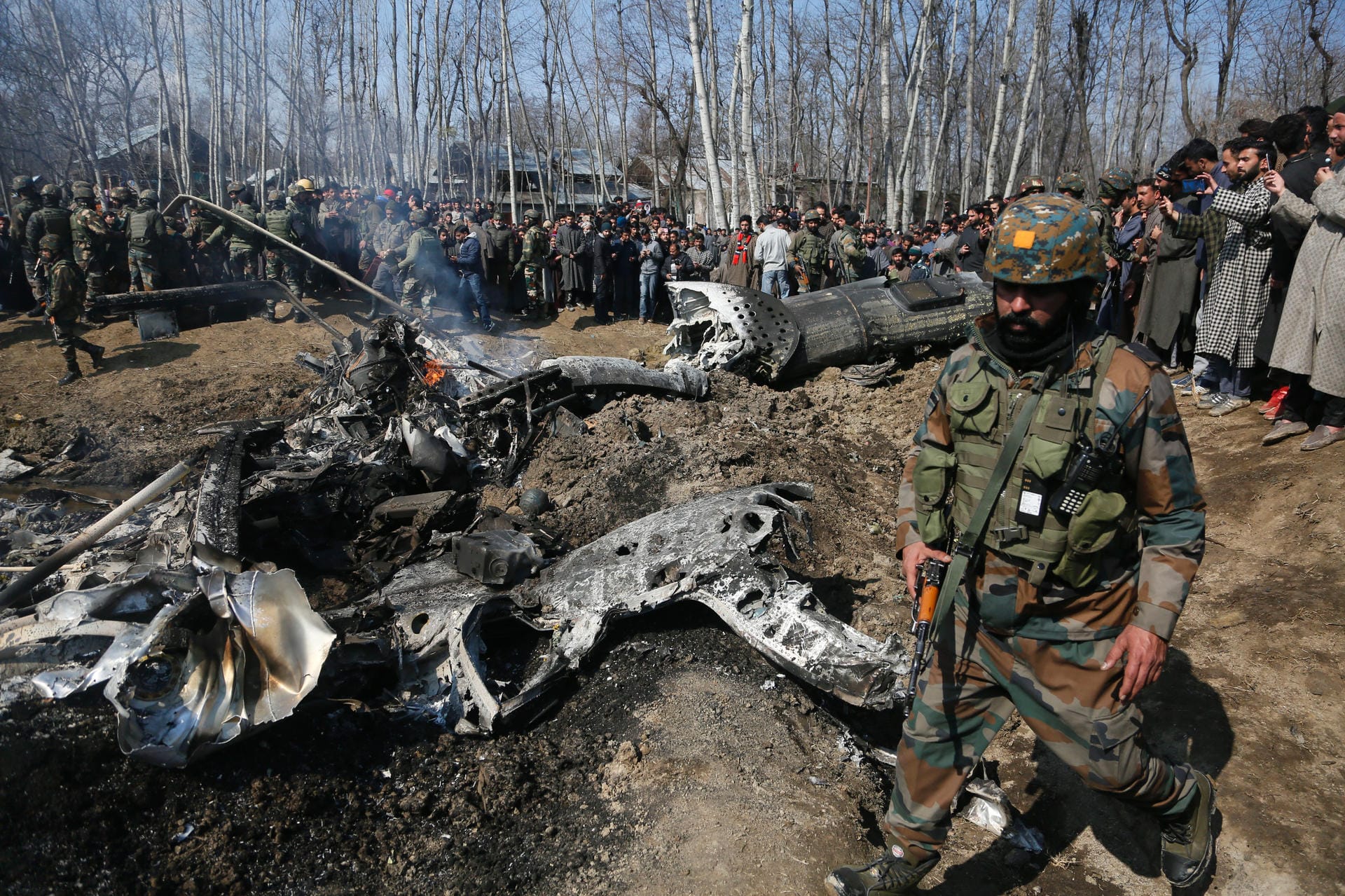 Soldaten stehen an Trümmer von Kampfjet