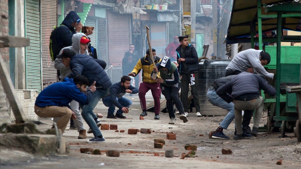Kaschmirische Demonstranten suchen bei Zusammenstößen mit indischen Sicherheitskräften Deckung.
