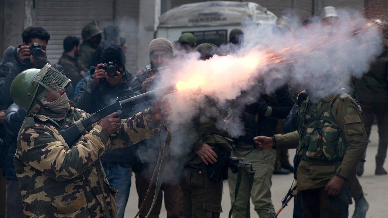 Ein indischer paramilitärischer Soldat feuert bei einem Protest gegen Razzien durch den indischen Geheimdienst in Kaschmir eine Tränengasgranate ab.