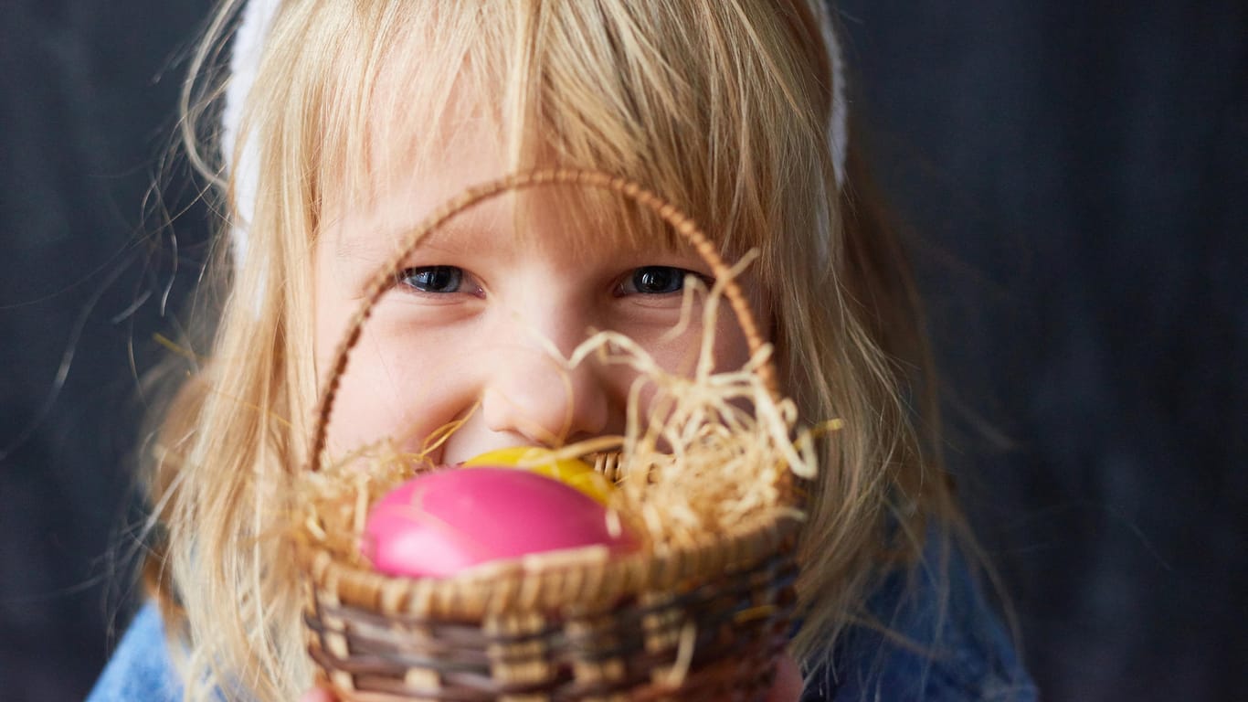 Mädchen mit Osternest: Neben dem Schokoladenosterhasen haben auch gefärbte Eier einen festen Platz im Körbchen.