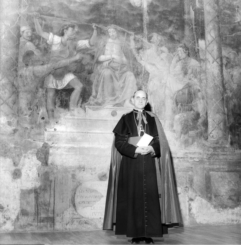 April 1956: Papst Paul VI. (Giovanni Battista Montini) posiert vor einem Wandgemälde. Der Italiener war von 1963 bis 1978 im Amt.