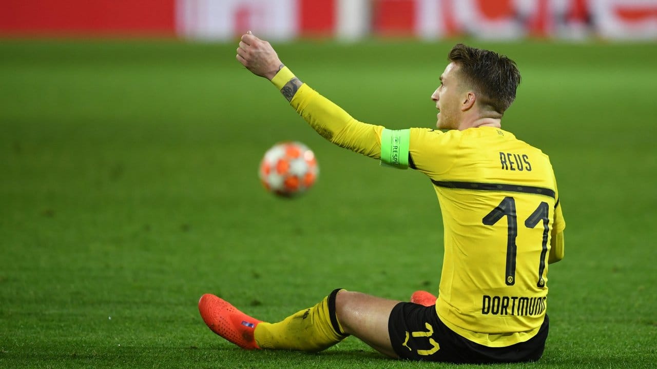 Dortmunds Kapitän Marco Reus sitzt auf dem Rasen und beschwert sich.
