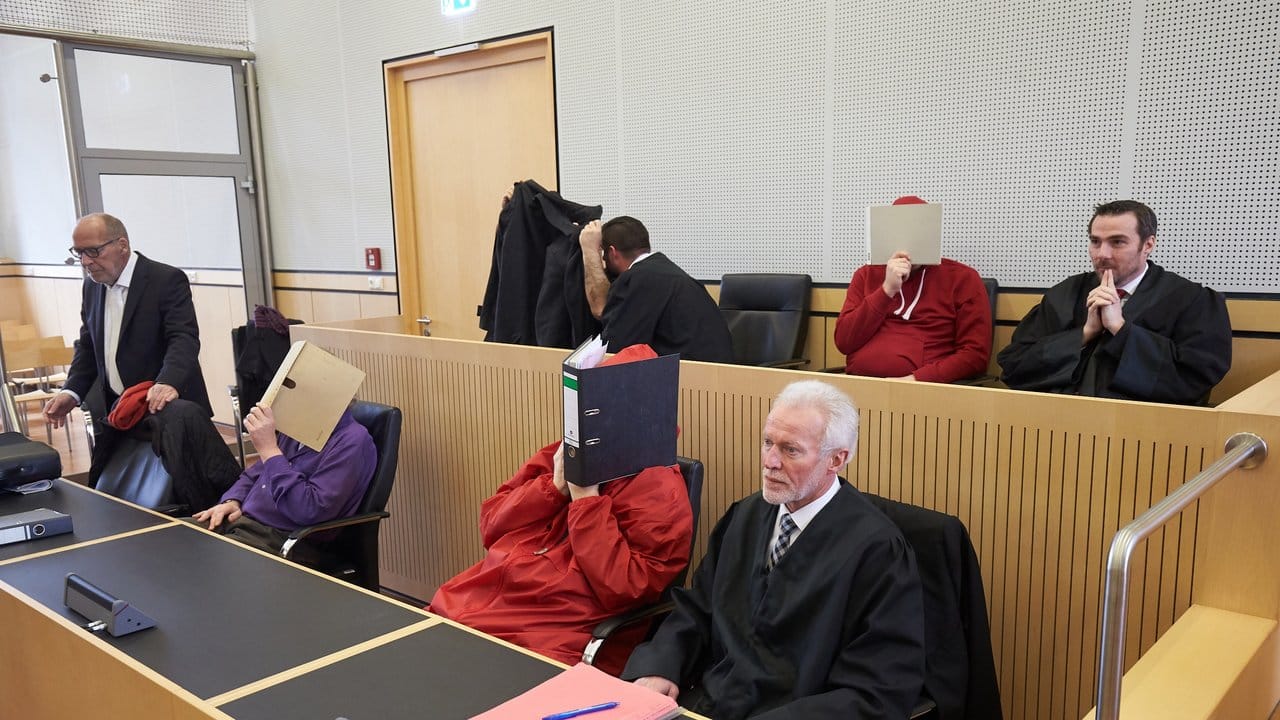 Im Landgericht Limburg verbergen die Angeklagten vor der Urteilsverkündung ihre Gesichter.