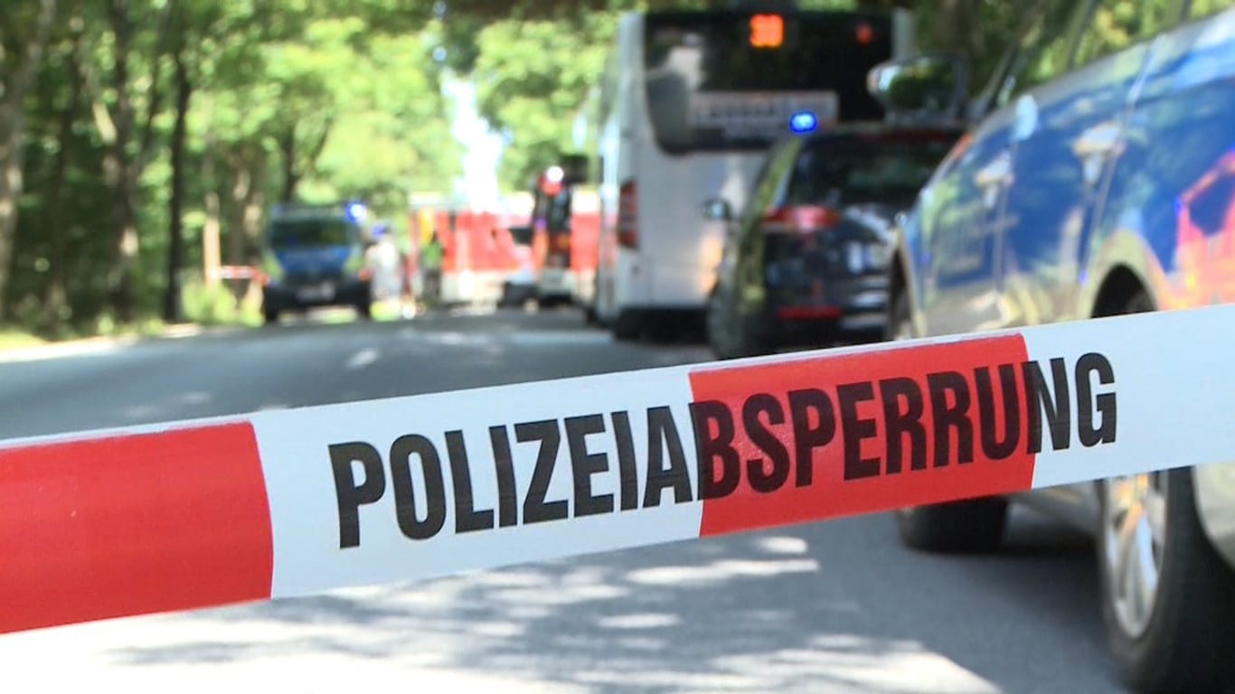 Ein Polizeiband sperrt die Straße hinter dem Linienbus, der am Rand abgestellt ist.