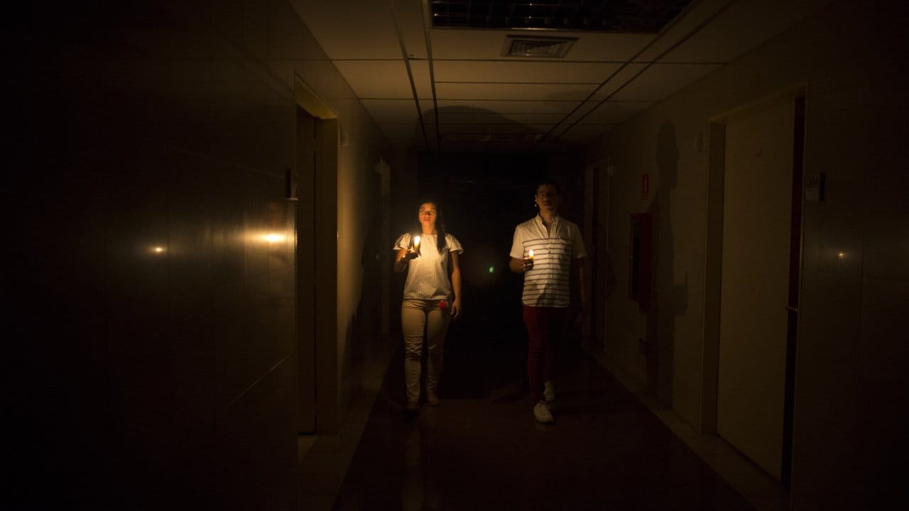 Im Dunklen: Verwandte eines Patienten gehen während des Stromausfalls mit einer Kerze über einen dunklen Gang in einer Klinik in Caracas.