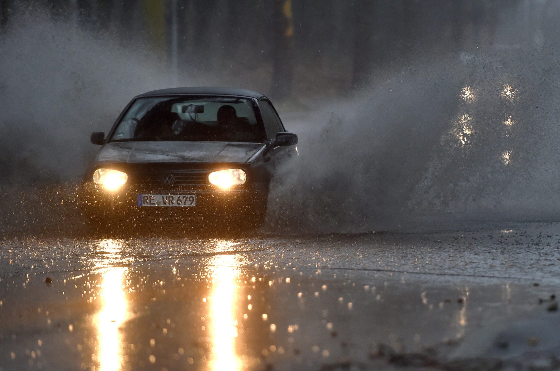 In Gelsenkirchen fährt ein Auto durch eine tiefe Pfütze. Der Sturm brachte teilweise auch Starkregen mit.