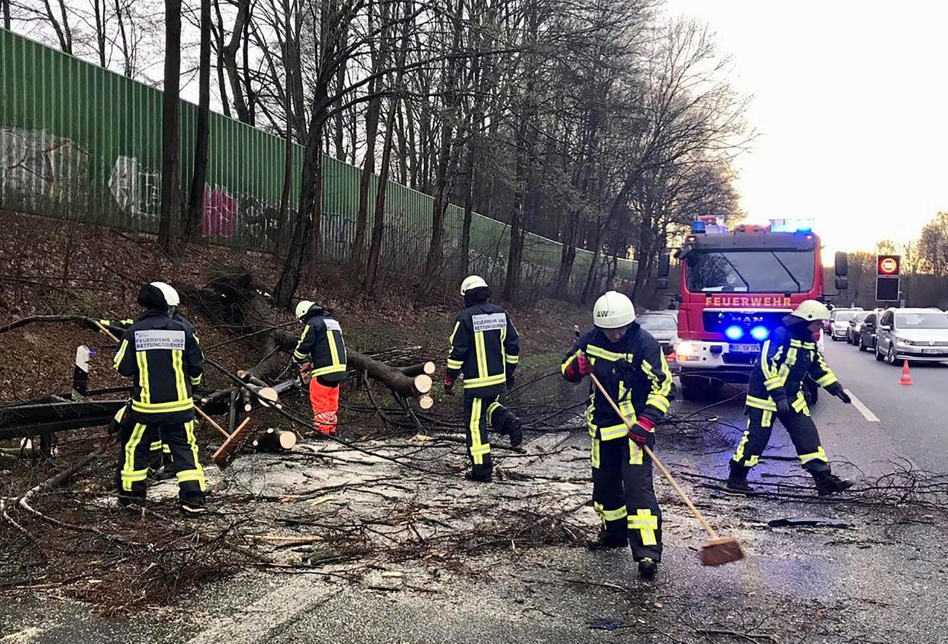 Feuerwehrleute räumen auf der Autobahn 40 in Bochum (Nordrhein-Westfalen) einen umgestürzten Baum von der Fahrbahn. Sturm Dragi hat am Wochenende in weiten Teilen Deutschlands Schäden verursacht.
