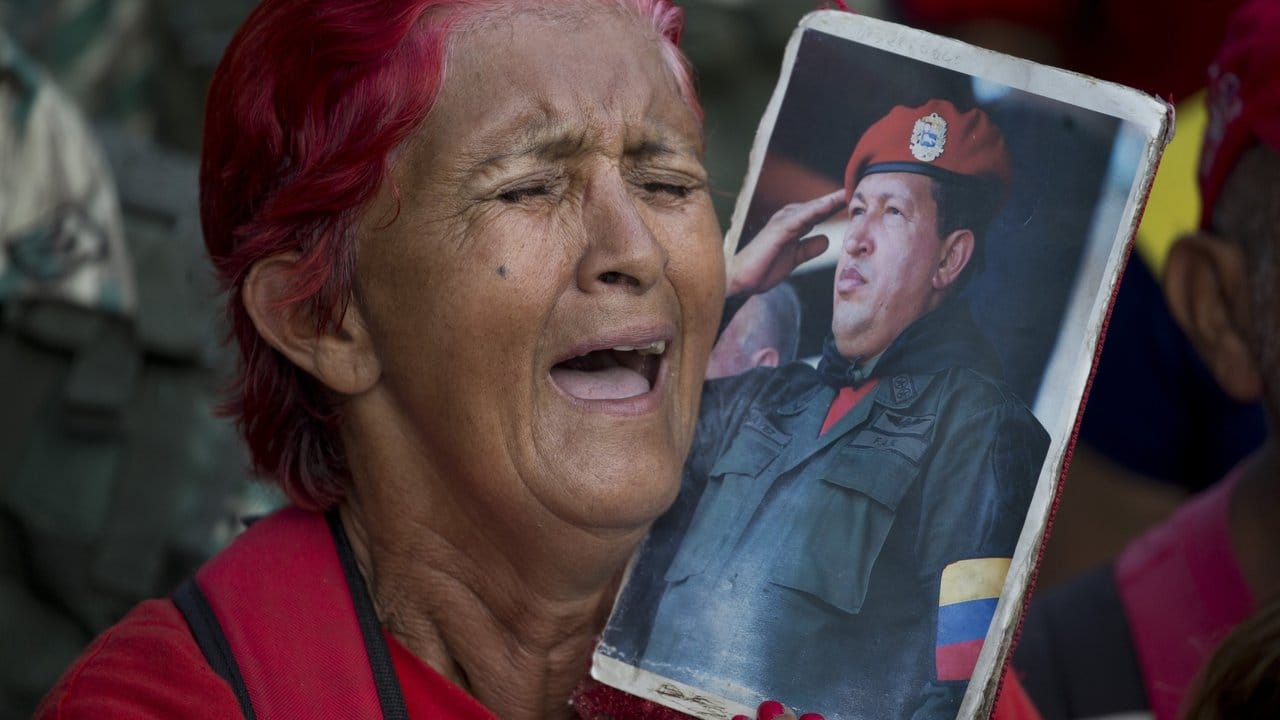 Eine Anhängerin von Venezuelas Präsident Maduro hält bei einer Kundgebung zur Unterstützung der Regierung ein Bild von Maduros Vorgänger, dem verstorbenen Präsidenten Chavez.