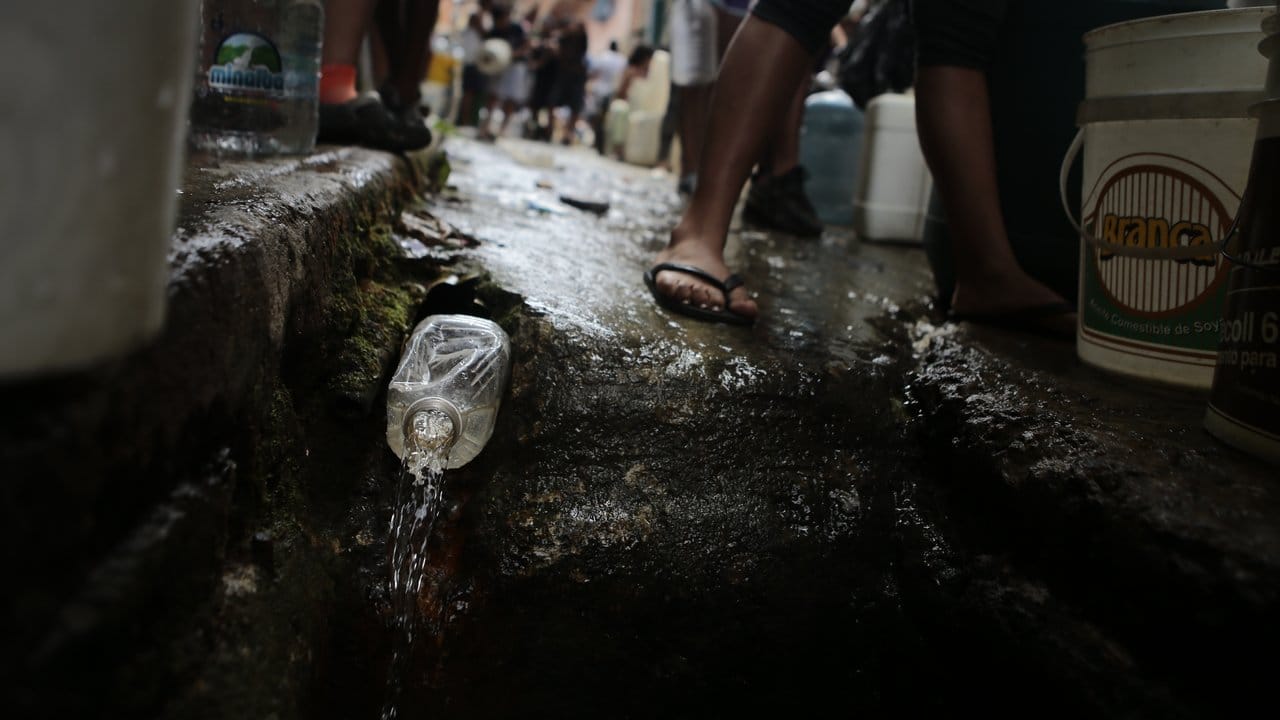 Eine Plastikflasche dient als Zapfhahn an einer Wasserleitung in einem ärmeren Viertel von Caracas, das aufgrund des massiven Stromausfalls keine Wasserversorgung hat.
