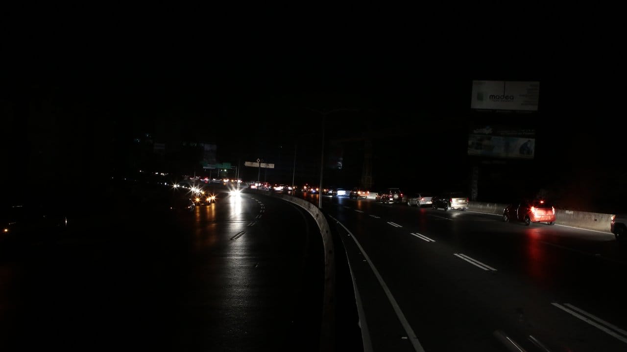 Autos fahren auf einer stockdunklen Autobahn durch die venezolanische Hauptstadt.