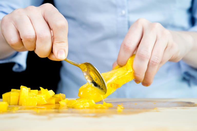 Mango: Schritt 6 – Das restliche Fruchtfleisch mit einem Teelöffel vom harten Kern abschaben.