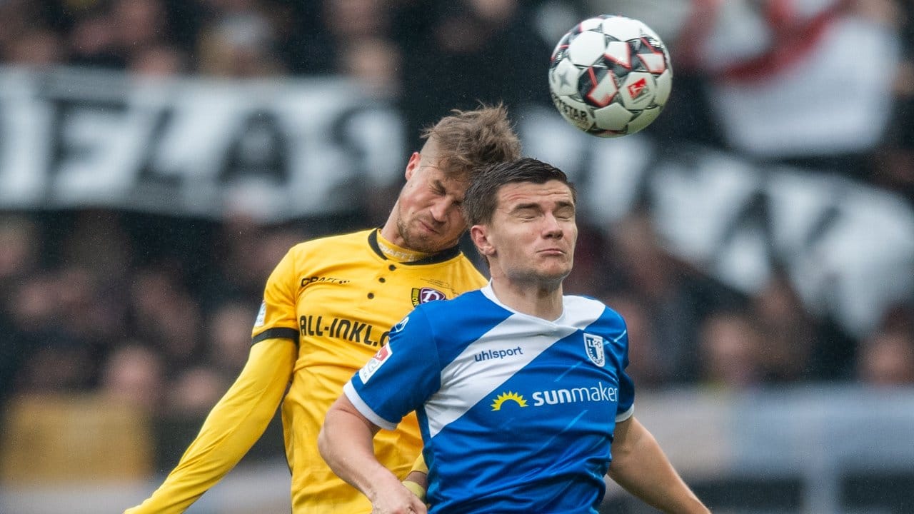 Dynamos Patrick Möschl (l) kämpft gegen den Magdeburger Björn Rother um den Ball.