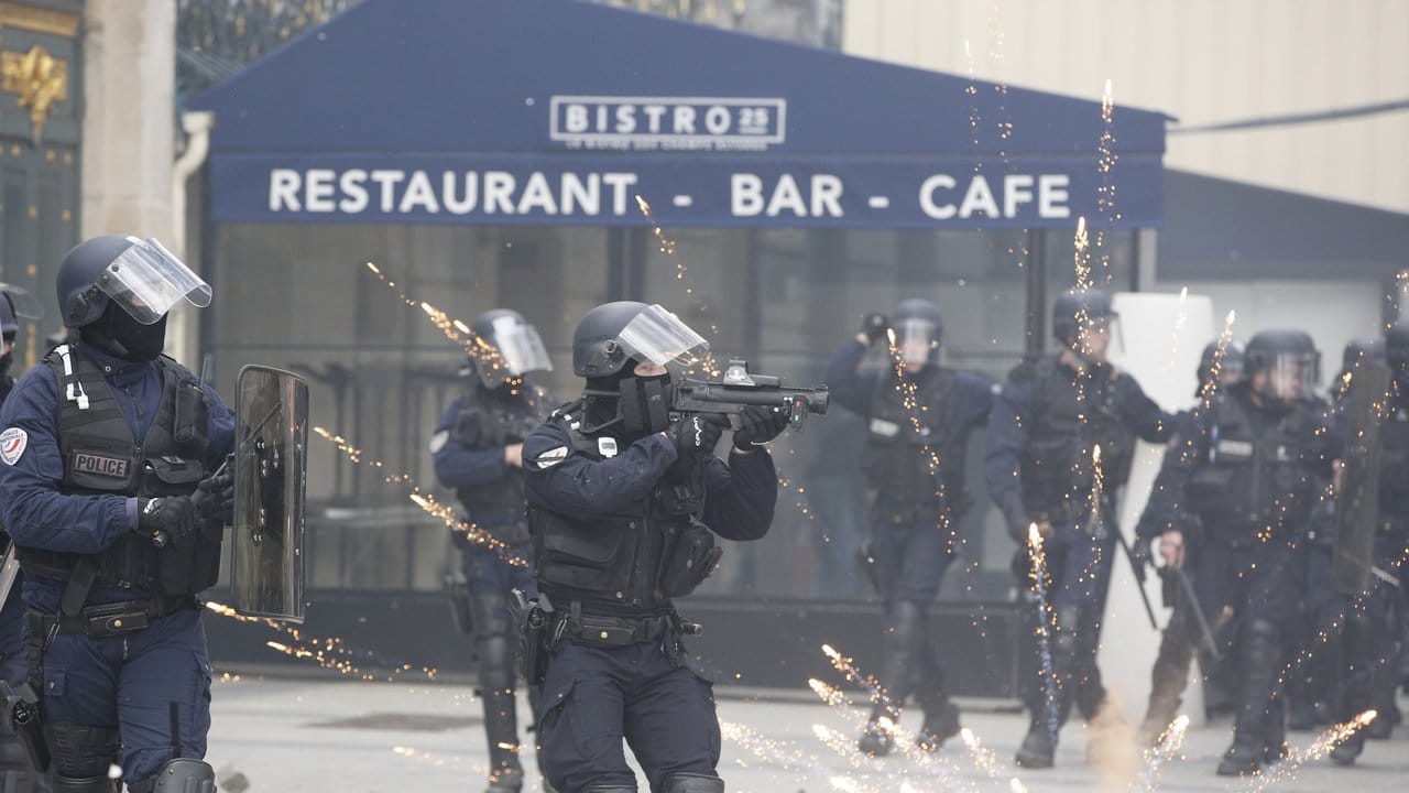 Ein Polizist zielt bei den "Gelbwesten"-Protesten auf den Champs-Elysees auf Demonstranten.
