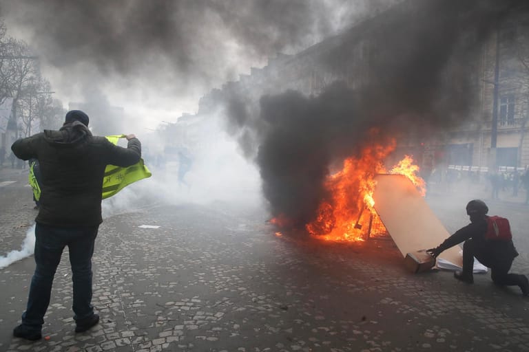 Demonstranten setzen eine Barrikade bei den "Gelbwesten"-Protesten in Brand. Auf dem Champs-Élysées kam es zu Ausschreitungen.