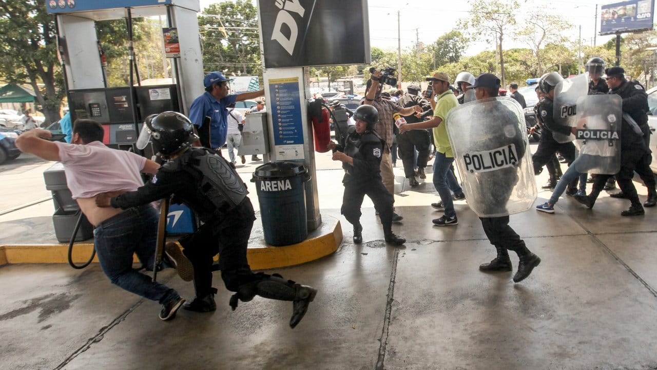 Polizisten gehen an einer Tankstelle in Managua gegen Demonstranten vor.