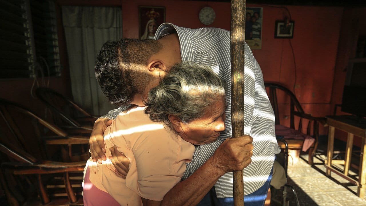 Enkel und Großmutter schließen sich in die Arme, nachdem der junge Mann aus dem Gefängnis entlassen und unter Hausarrest gestellt wurde.