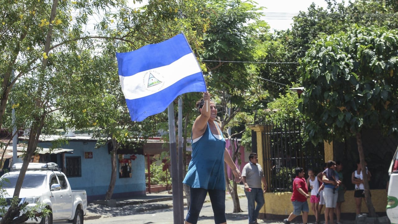 Eine Frau schwenkt eine nicaraguanische Flagge, um die Freilassung politischer Gefangener zu feiern.