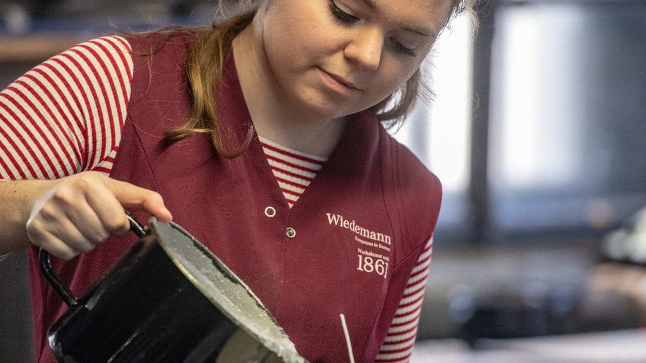 Alles Handarbeit: Franziska Hüttinger lernt in ihrem Betrieb, wie heißes, flüssiges Wachs bei der Kerzenherstellung richtig zu handhaben ist.