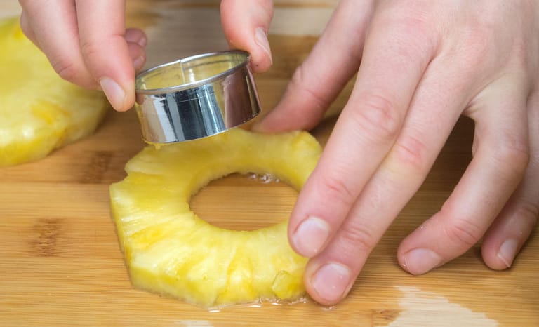 Ananas richtig aufschneiden: Schritt 7 – Den Strunk entfernt man am besten, indem man ihn mit einem Backförmchen aussticht.