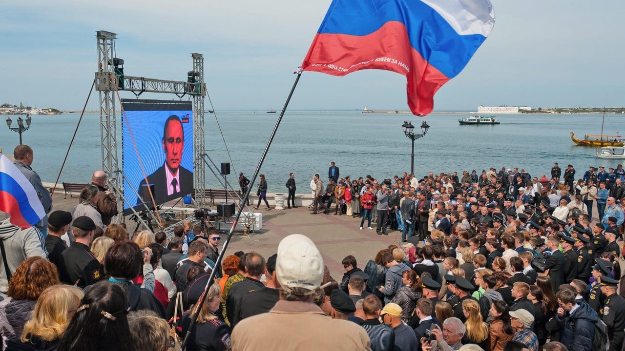 Menschen in Sewastopol bei einer Fernseh-Ansprache von Wladimir Putin: Auf der Krim wird der fünfte Jahrestag der umstrittenen Vereinigung mit Russland gefeiert.