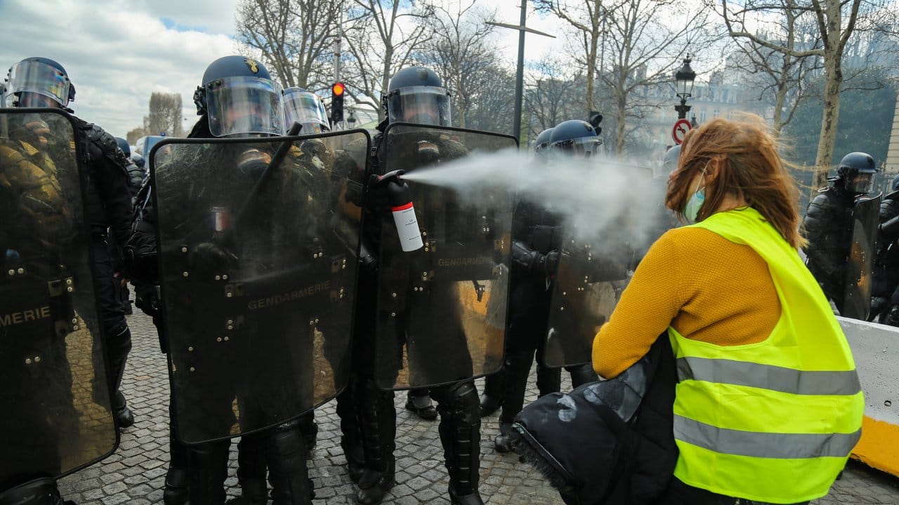 Französische Polizisten verwenden in Paris Pfefferspray gegen eine "Gelbwesten"-Demonstrantin.