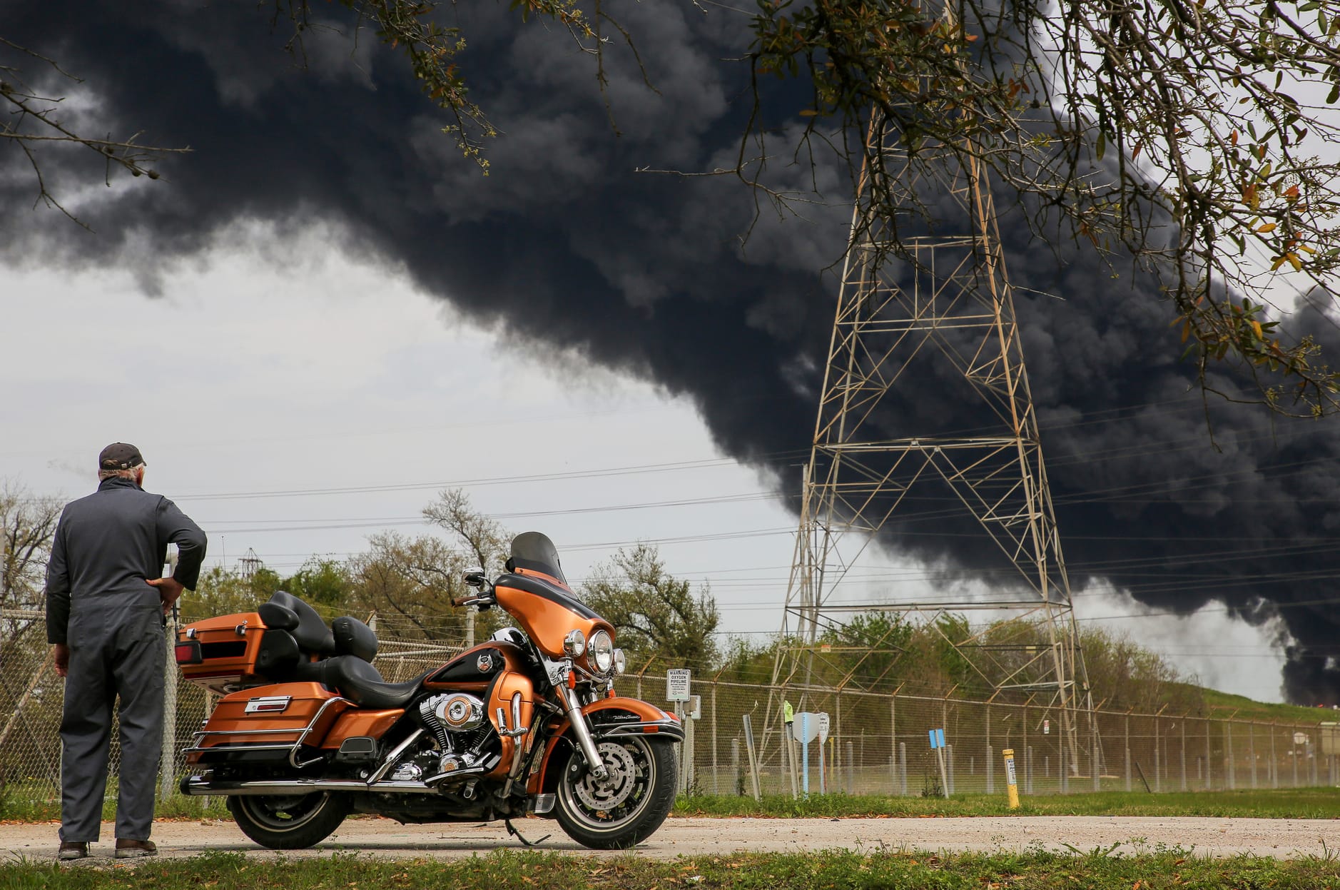 Ein Mann steht neben seiner Harley-Davidson während er den Rauchwolken zuschaut: Einige Anwohner klagten über Atembeschwerden.