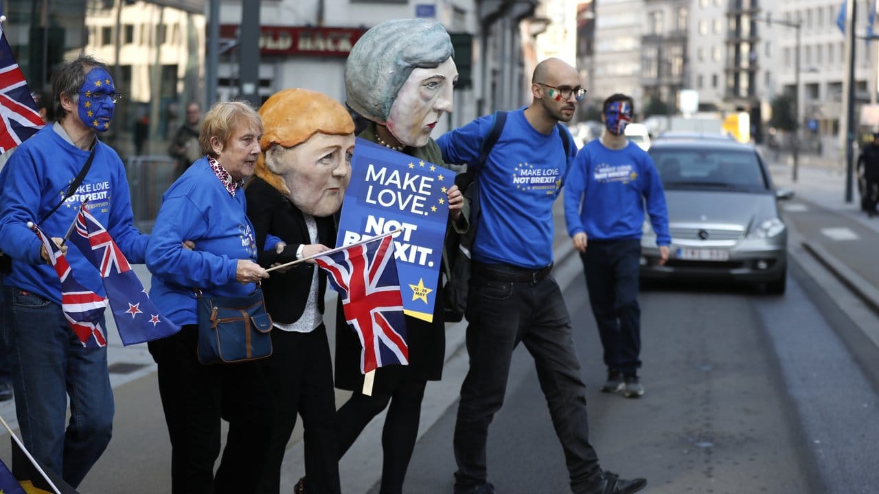 Aktivisten halten ein Schild mit der Aufschrift "Make Love Not Brexit" vor dem EU-Hauptsitz hoch.