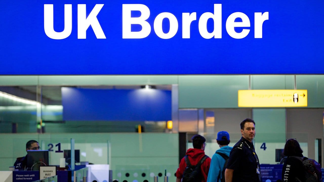 Grenzbeamte am Londoner Flughafen Heathrow unter einem Grenzschild.