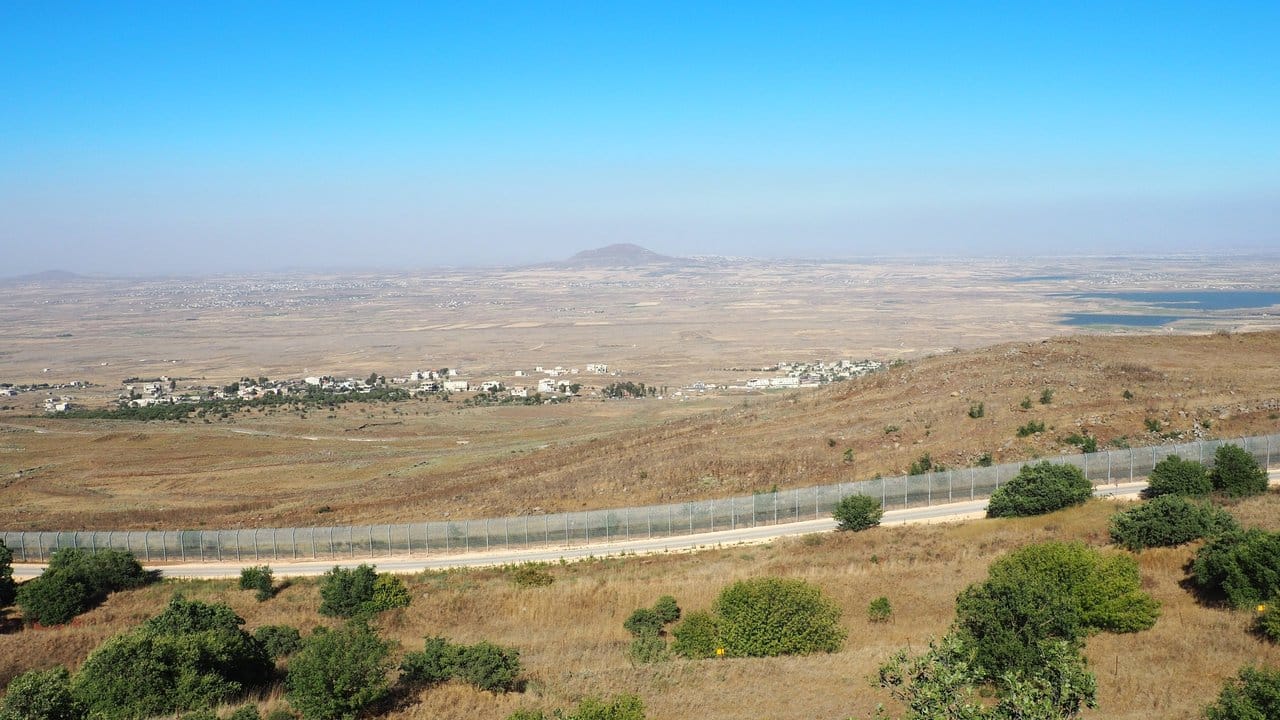 Blick von einem Hügel der Golanhöhen über den Grenzzaun nach Syrien und den Ort Birajam mit rund einem Dutzend Zelten von syrischen Flüchtlingen.