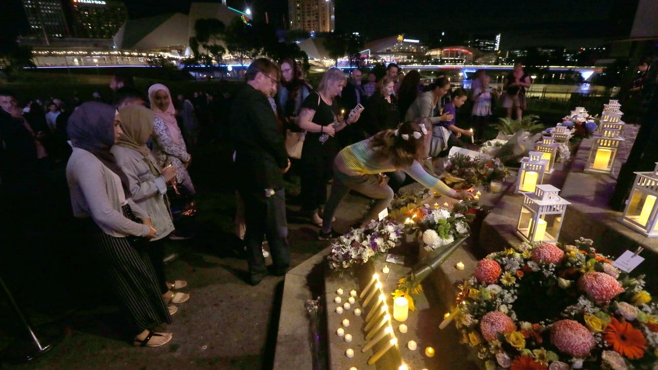 Teilnehmer einer Mahnwache legen Blumen für die Opfer des rassistisch motivierten Anschlags von Christchurch nieder.