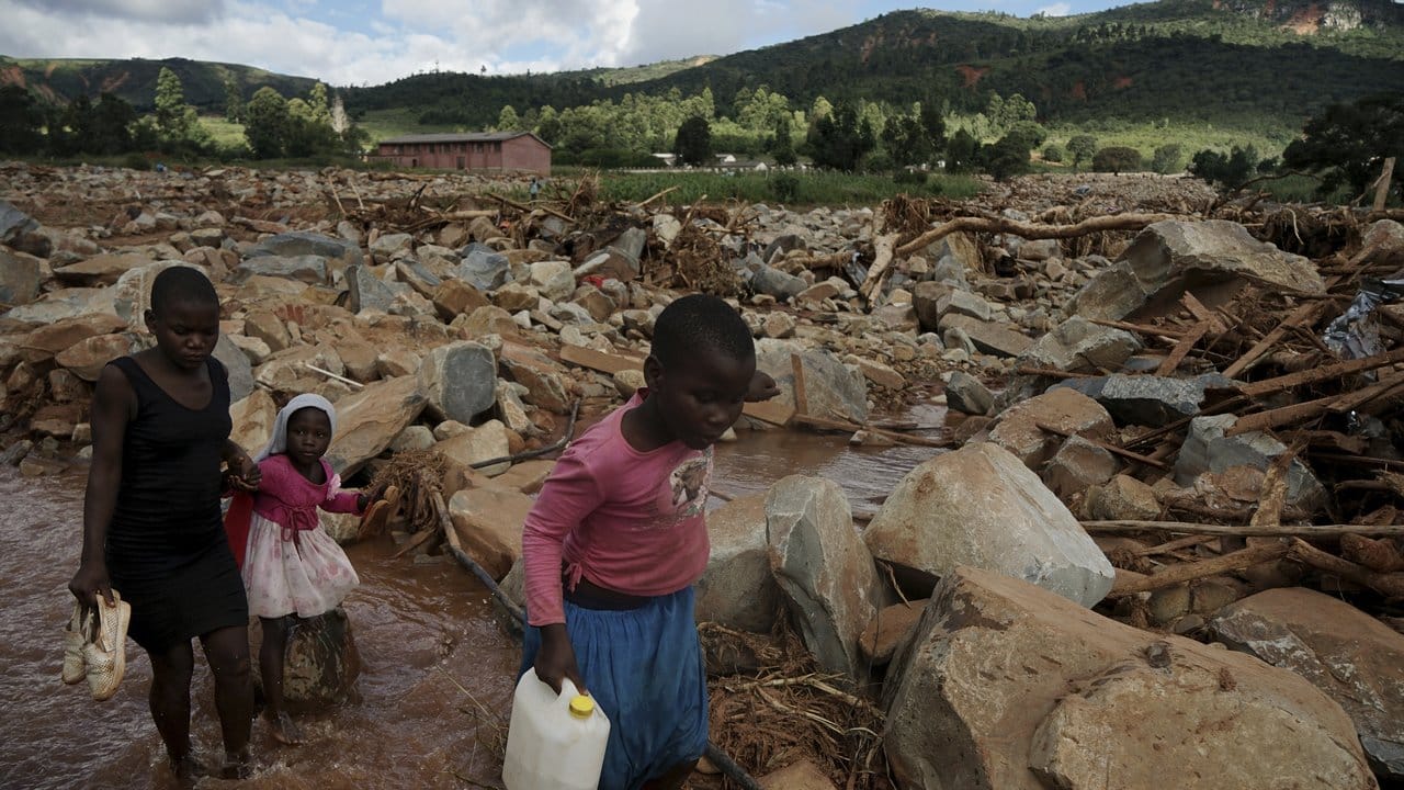 In Chimanimani in Simbabwe überqueren Kinder einen nach Zyklon "Idai" mit Geröll gefüllten Bachlauf.