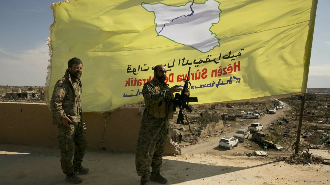 Kämpfer der von den USA unterstützten Syrischen Demokratischen Kräfte (SDF) hissen ihre Flagge über Baghus.