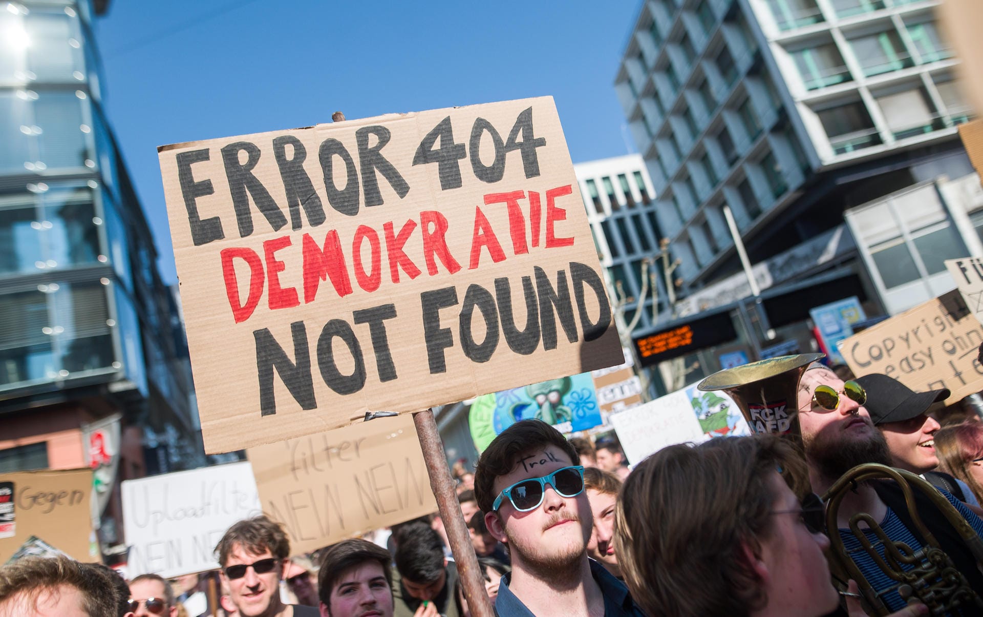 "Error 404 Demokratie not found" steht auf einem Transparent eines Demonstranten in Stuttgart.