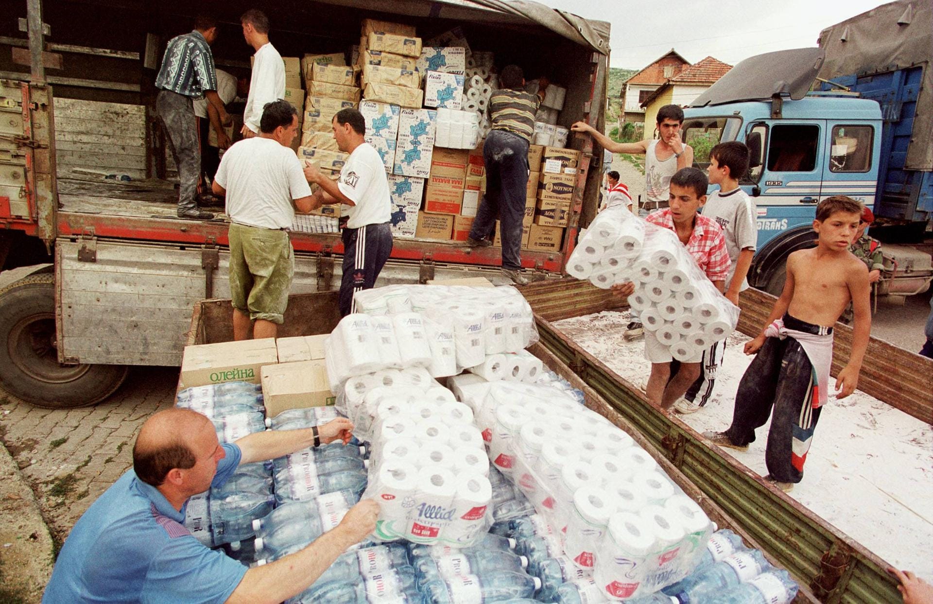 Bewohner der Enklave entladen Hilfsgüter, welche mit einer Hilfskonvoi des jugoslawischen Roten Kreuz aus Belgrad gekommen sind.