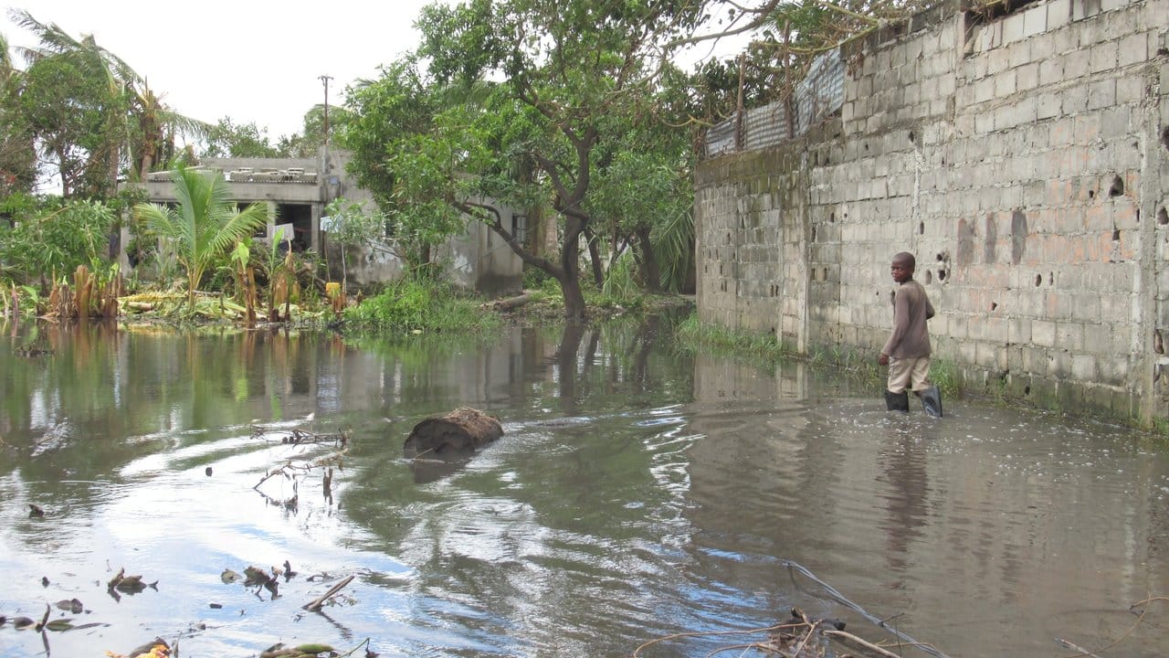 Ein Junge watet durch das Hochwasser zu seinem Haus in der Stadt Beira.