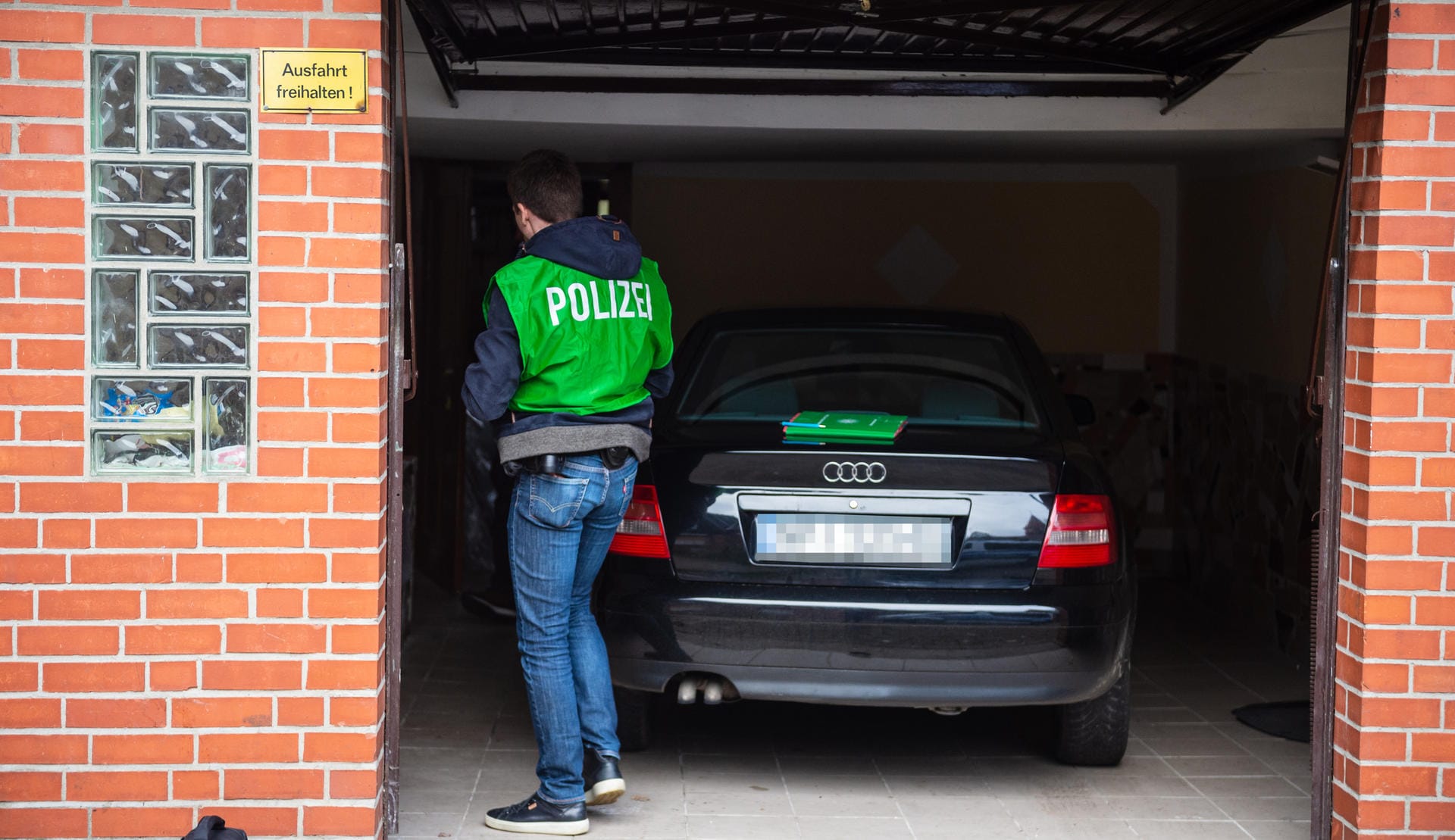 Niedersachsen, Wriedel: Ein Polizist durchsucht eine Garage bei einer Razzia wegen des Verdachts des banden- und gewerbsmäßigen Betrugs.