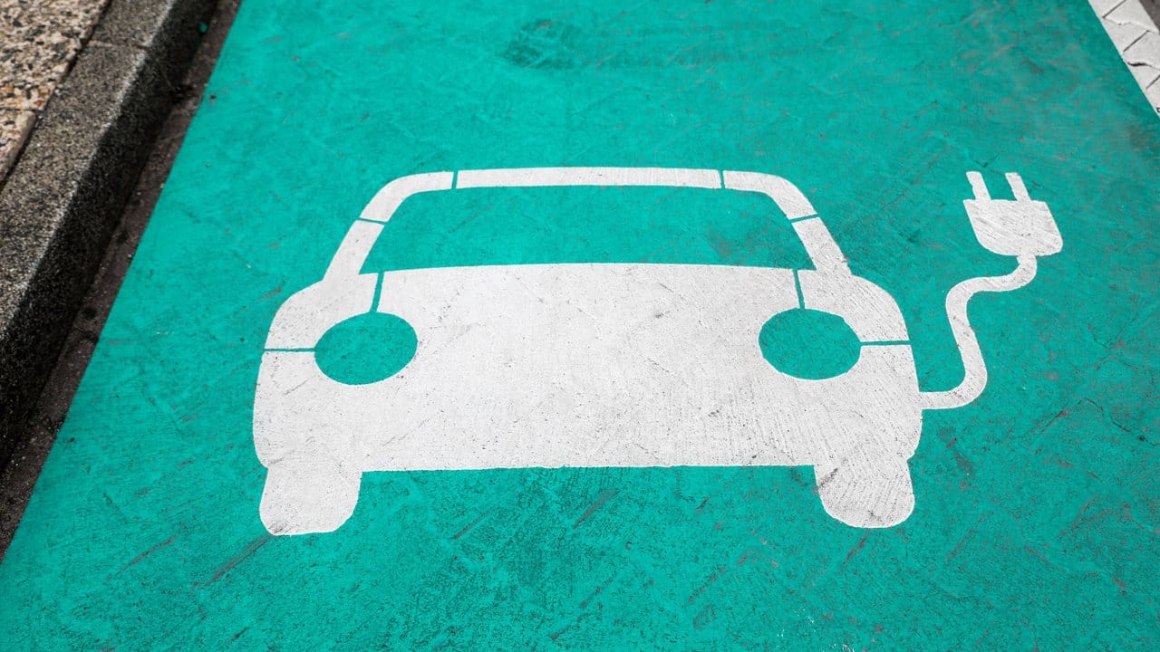 Ein Piktogramm markiert einen Parkplatz mit Ladesäule für Elektrofahrzeuge.