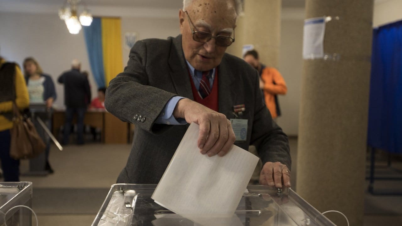 Ein Mann wirft in Kiew seinen Stimmzettel in eine Wahlurne.