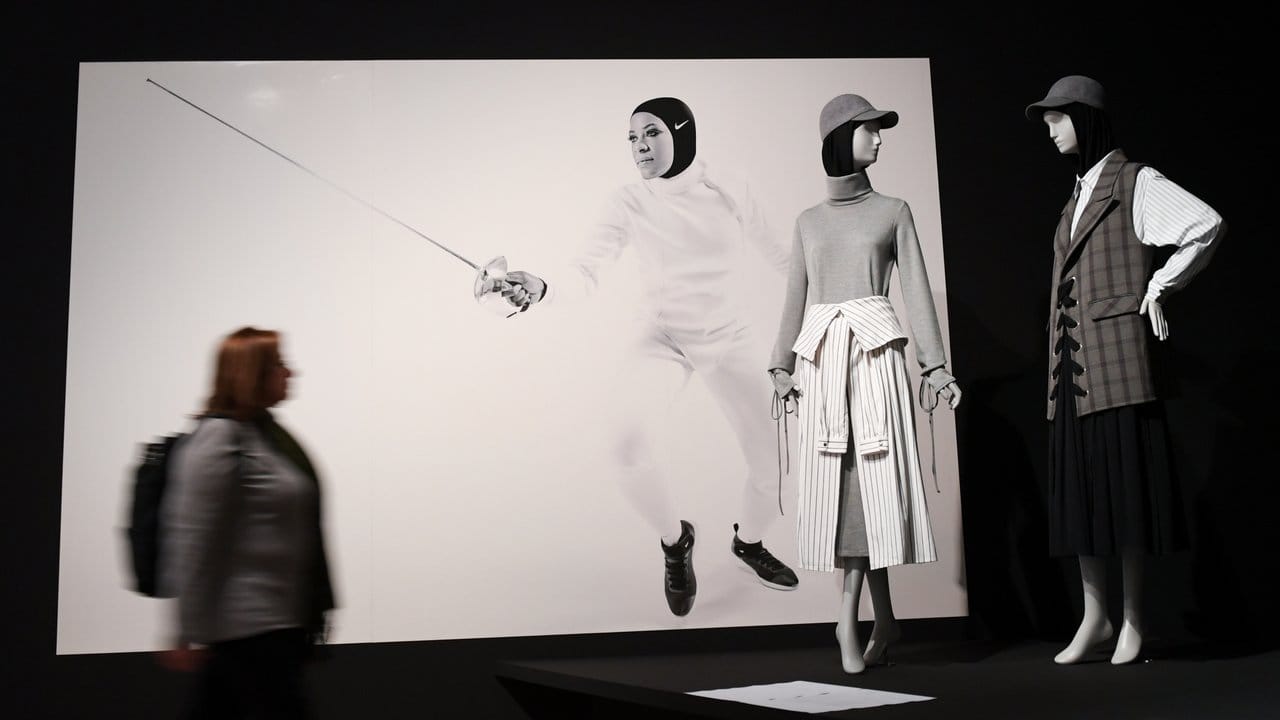 Sportbekleidung und ein Nike-Werbefoto, das eine Fechterin zeigt.
