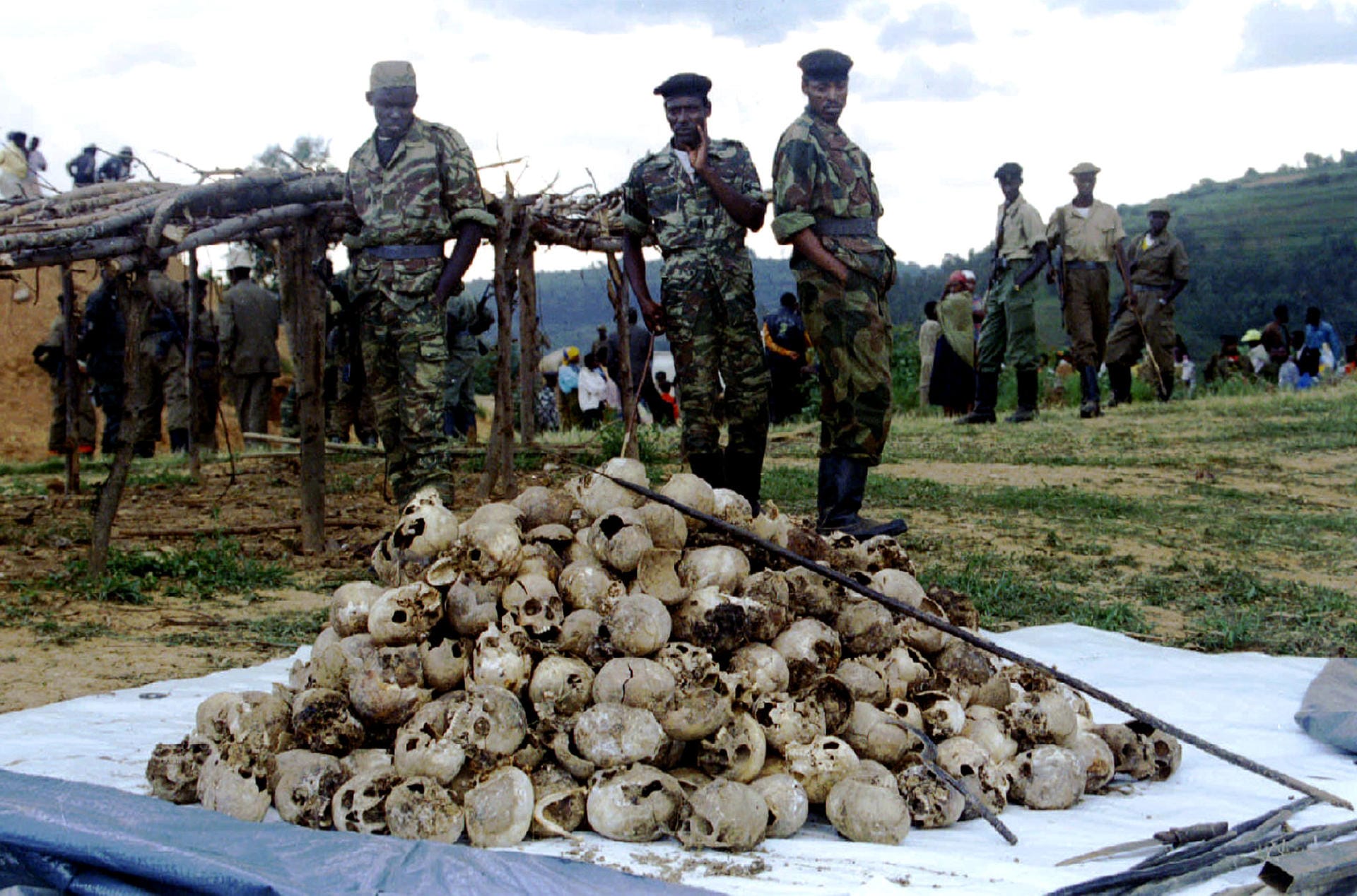 Members of the Rwandan Patriotic Front observe March l9 the skulls of several hundred Tutsi civilian..