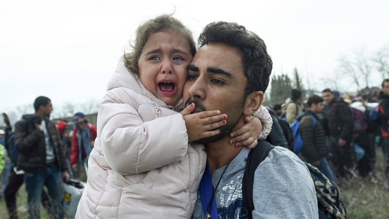 Ein Mann hält ein weinendes Mädchen.