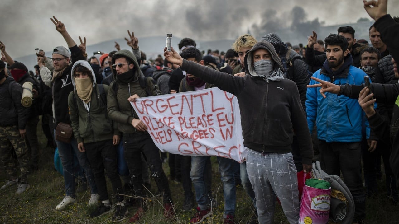 Protestierende Migranten halten ein Banner mit der Aufschrift "Schnell, Bitte, Bitte EU, helft den Migranten in Griechenland" bei Zusammenstößen mit der Polizei in der Nähe von Thessaloniki.