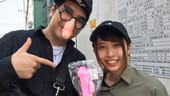 Besucher des Phallus-Festivals zeigen Souvenirs: Die japanischen YouTuber Shinya (l) und Yuriyuri zeigen beim Phallus-Festival einen rosafarbenen Penis-Lolli.