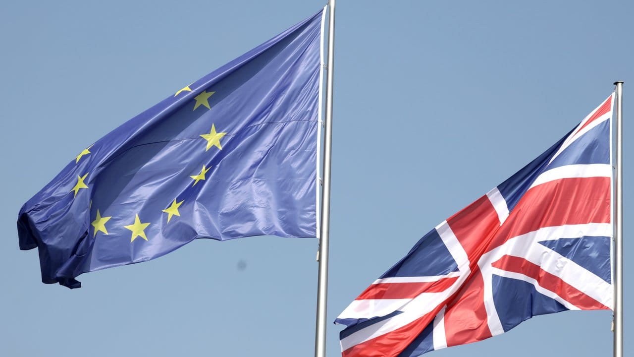 Die Flaggen der EU und Großbritanniens wehen vor dem Bundeskanzleramt in Berlin im Wind.