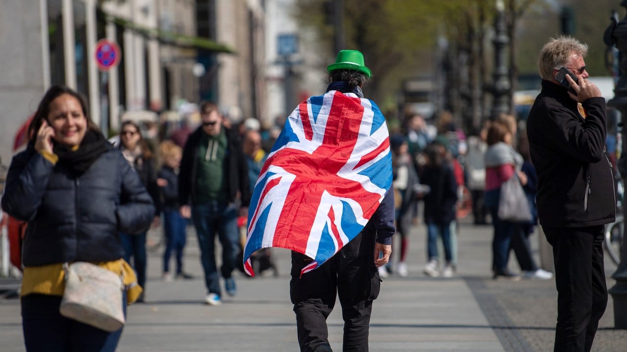 Ein Mann läuft mit einer britischen Flagge auf dem Rücken durch Berlin.