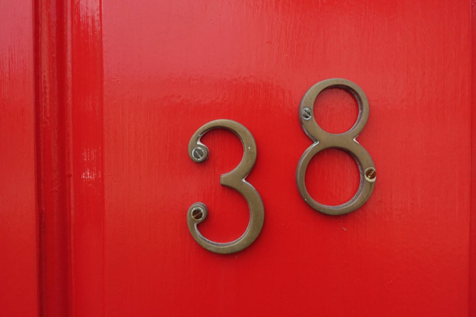 Die Hausnummer 38 befindet sich hier auf einer typisch roten Haustür in der britischen Stadt Canterbury.