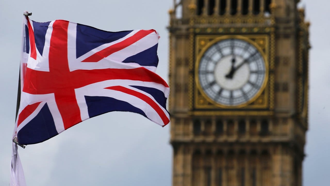 Die britische Nationalflagge, der Union Jack, weht vor dem Uhrturm Big Ben.