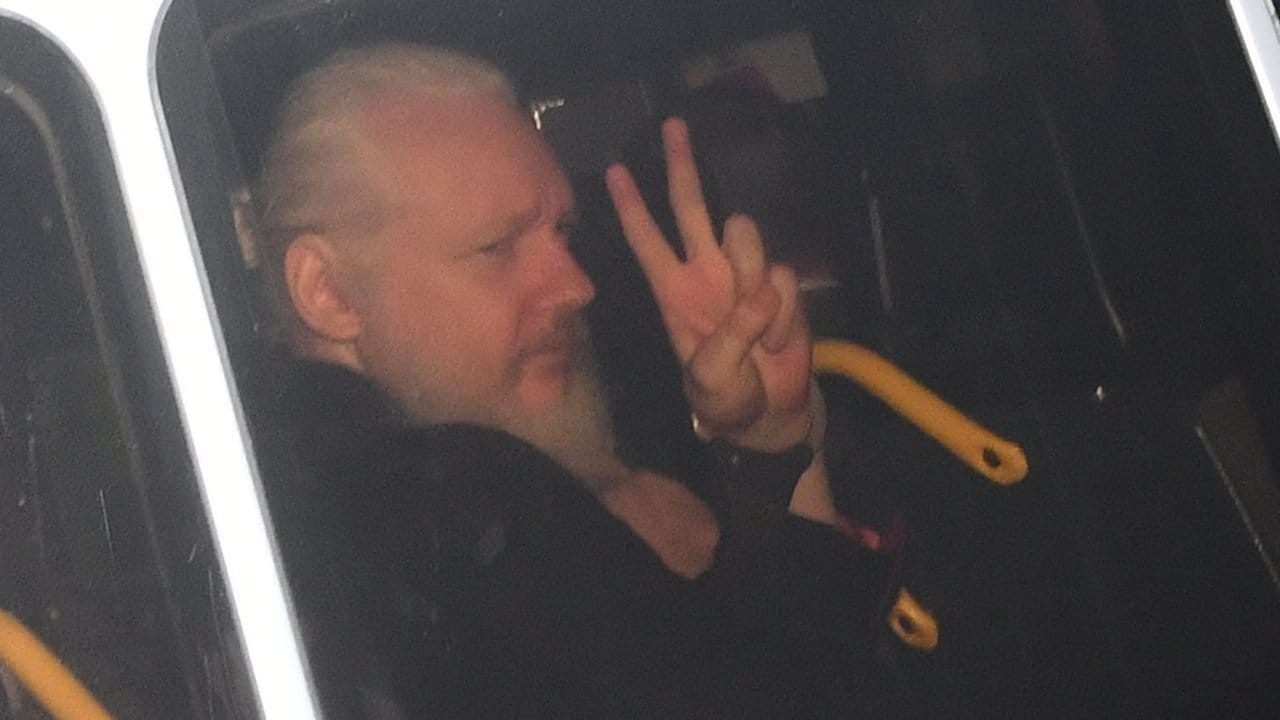 Julian Assange zeigt nach seiner Festnahme das Victory-Zeichen.