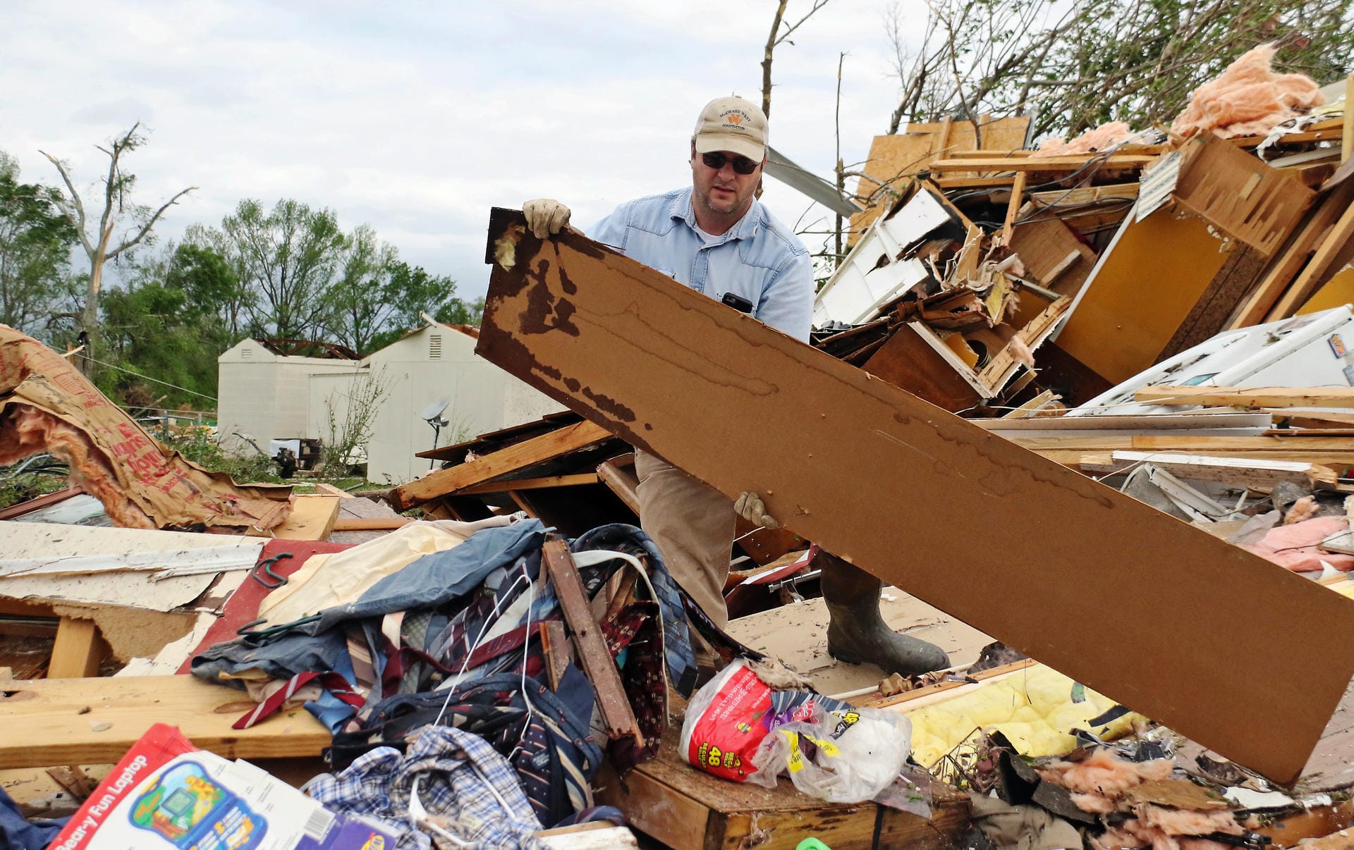 Ein Anwohner aus Hamilton hilft bei Bergungsarbeiten mit: Roman Brown räumt Teile eines zerstörten Hauses zur Seite, während er für einen Freund nach Medizin sucht.